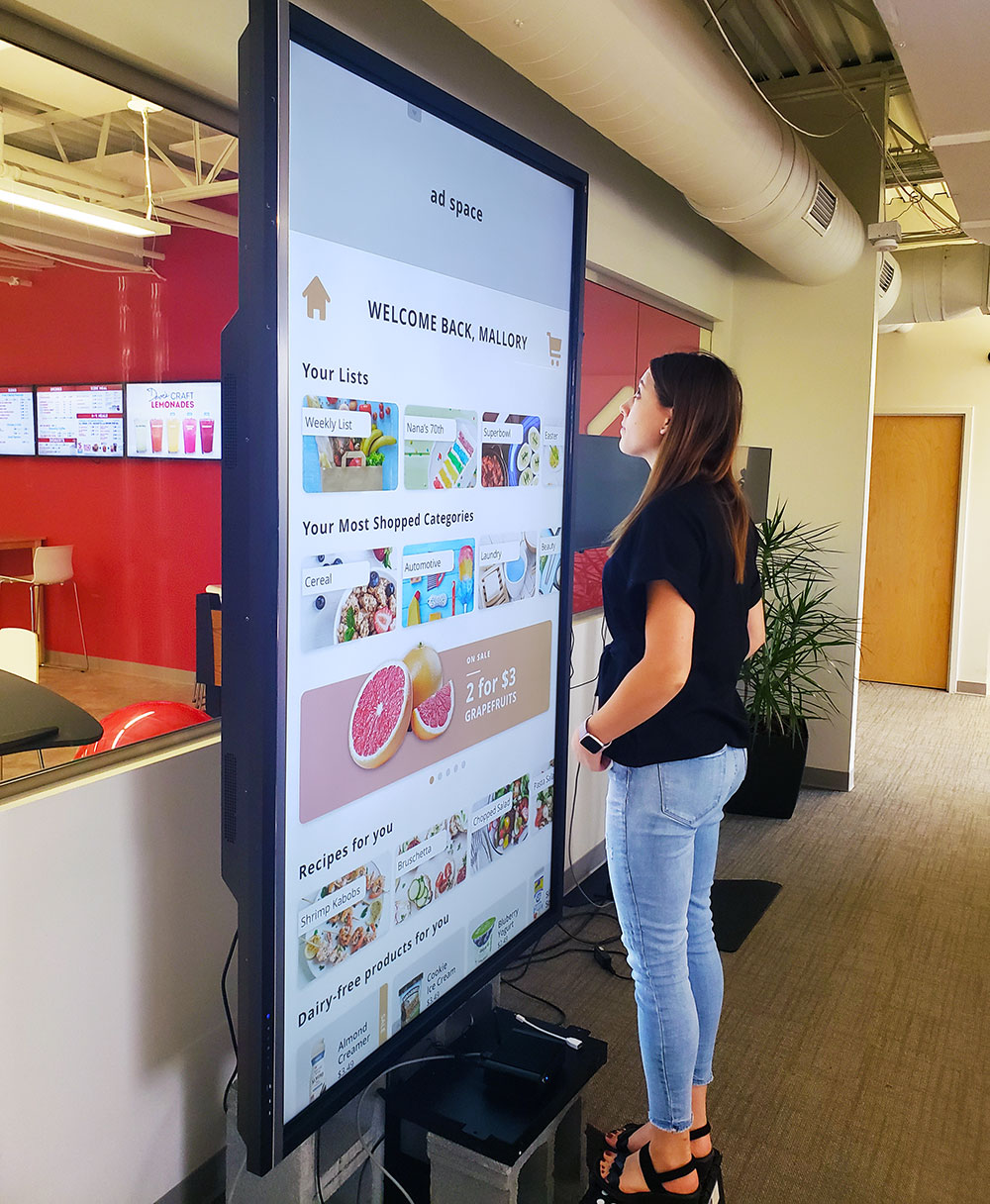 Mallory standing by an 86" screen testing the scale