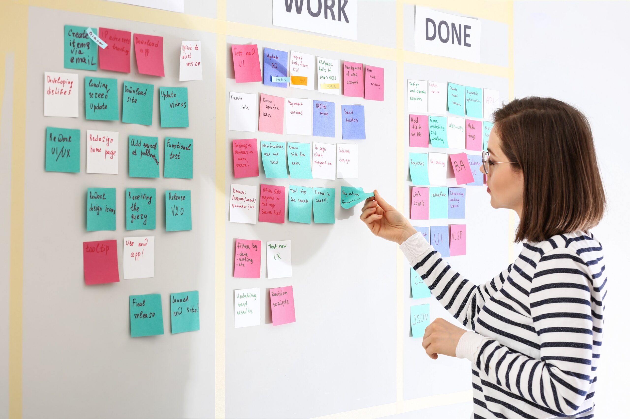 The cover image of an article, a woman looking at a wall of sticky notes