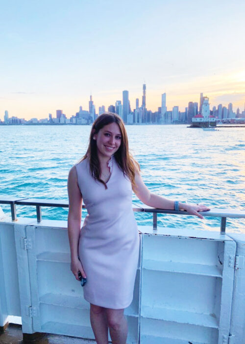 Mallory smiling and standing by the ocean on a boat